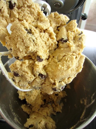Chocolate chip cookie dough on the paddle of a stand mixer