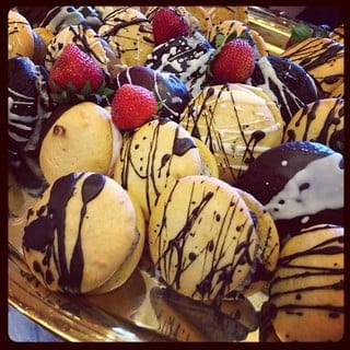 Close-up of a tray of desserts drizzled in chocolate and topped with fresh berries