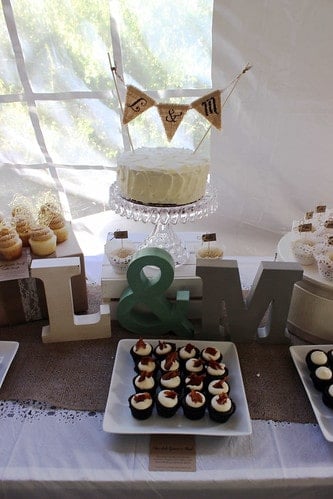 A table of DIY wedding cake and cupcakes