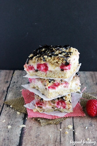 A stack of raspberry cheesecake bars with streusel topping