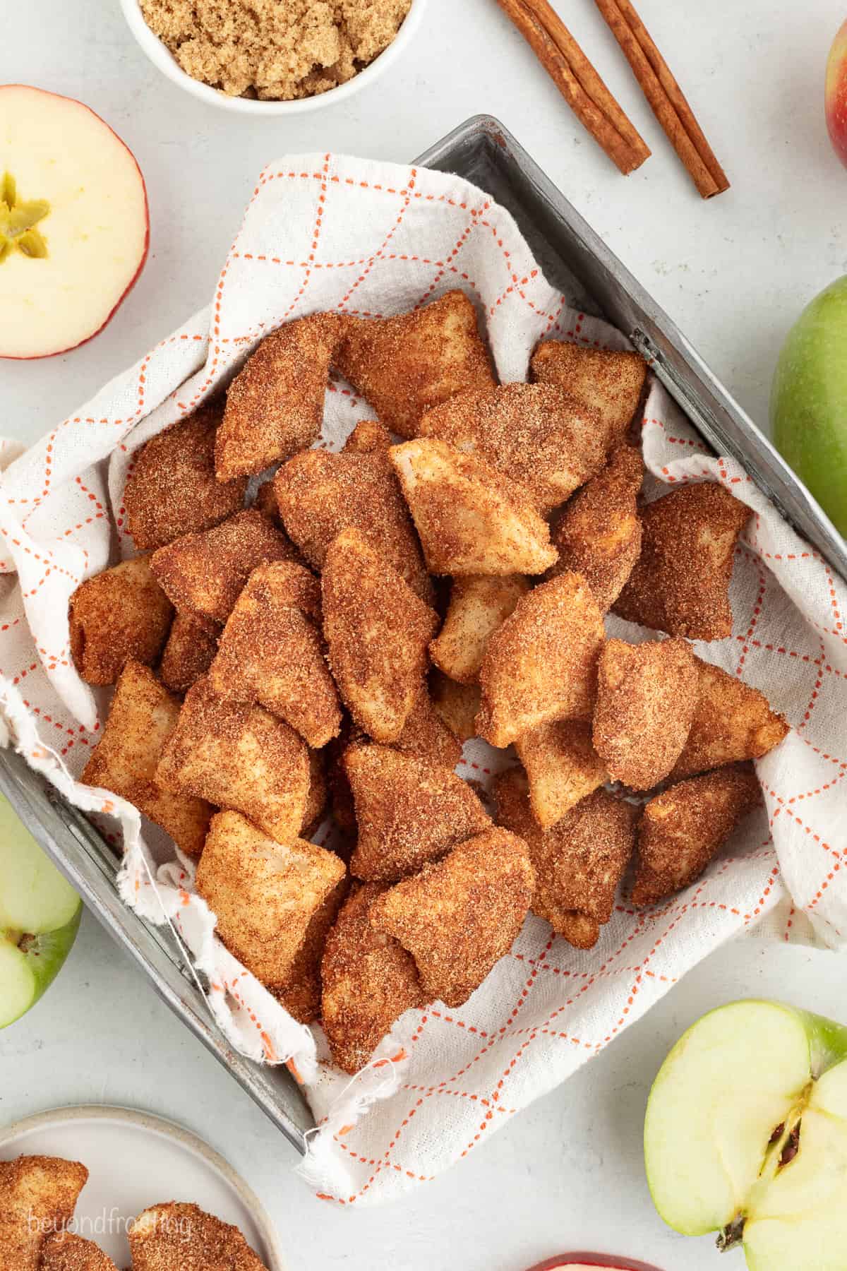 Overhead view of a basket of golden-fried apple pie bites.