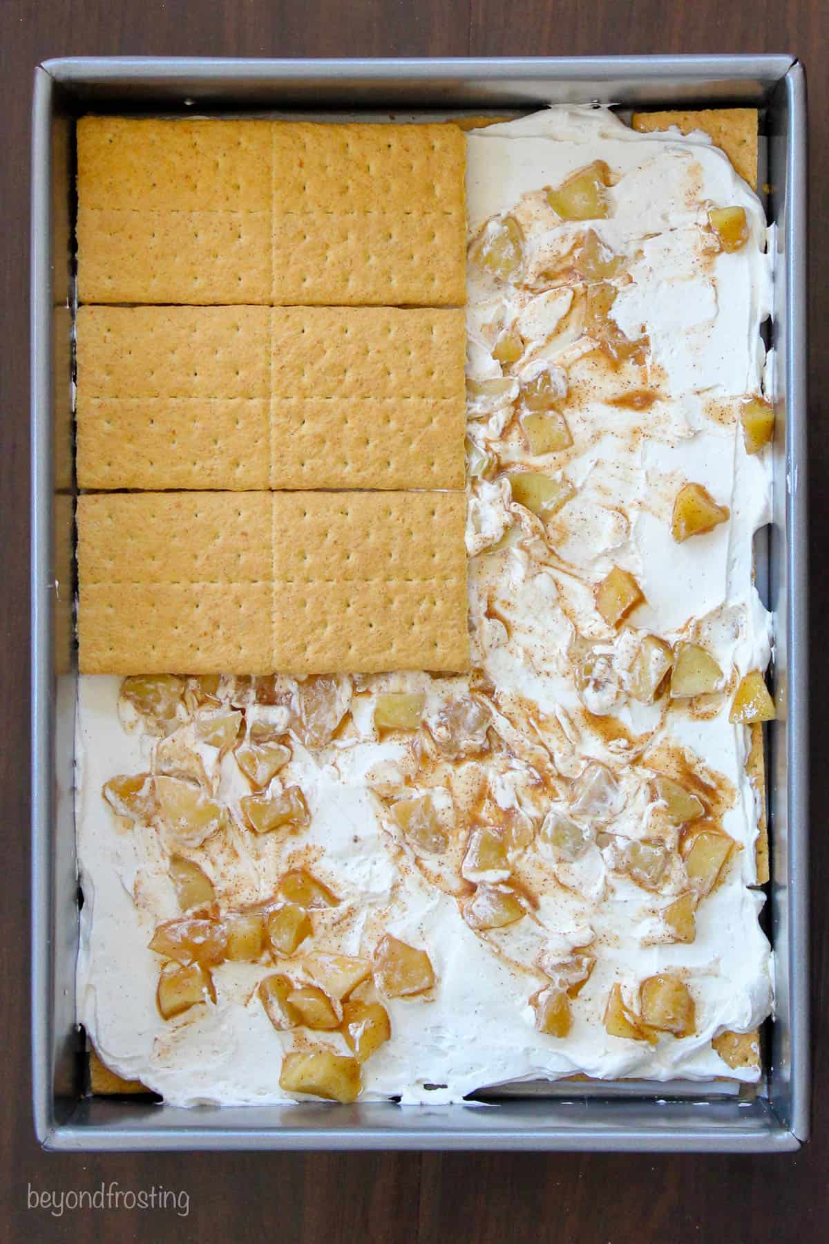 graham crackers being layered over apple pie filling