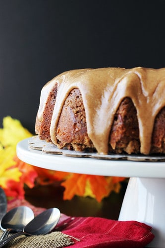 Apple Pie Coffee Cake with Maple Brown Butter Glaze on a white cake stand