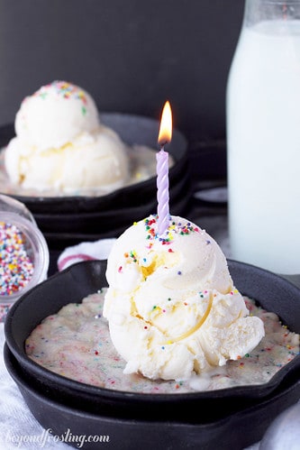 Skillet cookie with a scoop of ice cream and a candle