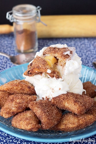 Deep fried apple pie bites on a plate with whipped cream
