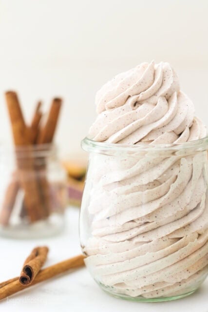 Cinnamon maple whipped cream piped into a clear glass jar.