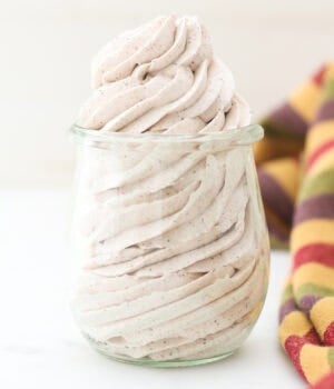 Cinnamon maple whipped cream piped into a clear glass jar.