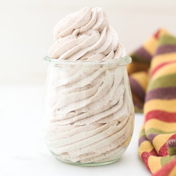 Cinnamon maple whipped cream piped into a clear glass jar.