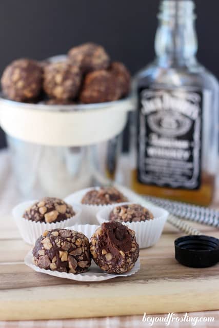 Chocolate Toffee Truffles in paper cups in front of a bottle of Jack Daniels Whiskey