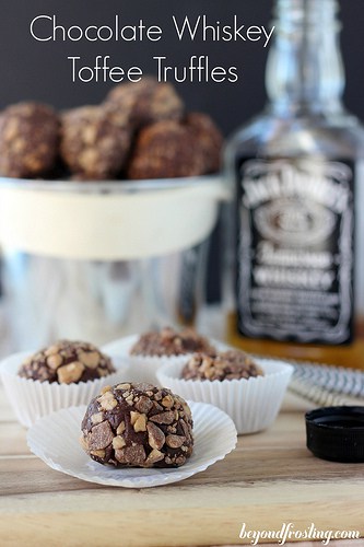 Whiskey Chocolate Toffee Truffles in paper muffin cups in front of a bottle of Jack Daniel's Whiskey