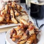 A plate of loaded doughnut fries on a table with another full plate in the background