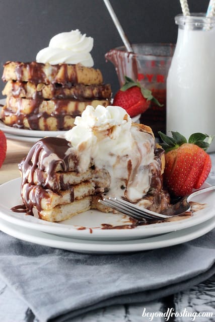 A stack of Bailey's French Toast on a plate with a couple bites removed