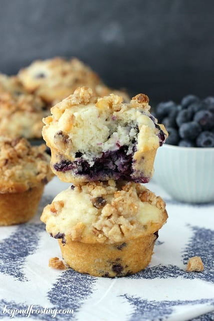 Two Coconut Blueberry Muffins Stacked with a bite removed from the top one