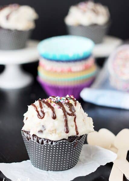 A chocolate cupcake topped with Hot Fudge Sundae Frosting and a drizzle of chocolate sauce.