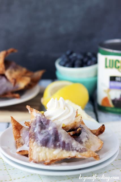 Blueberry Cheesecake Wontons on a plate in front of ingredients