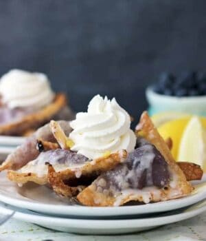 These blueberry cheesecake wontons are filled with fresh blueberry and topped with cream.