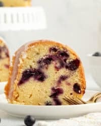 A slice of lemon blueberry bundt cake on a plate next to a fork.