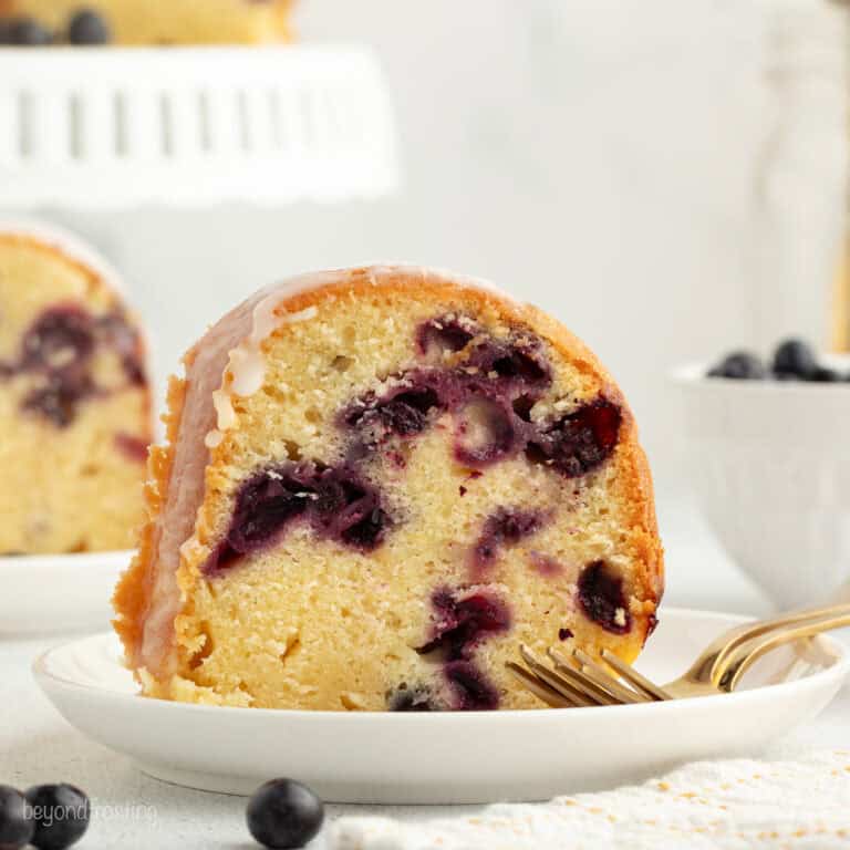 A slice of lemon blueberry bundt cake on a plate next to a fork.