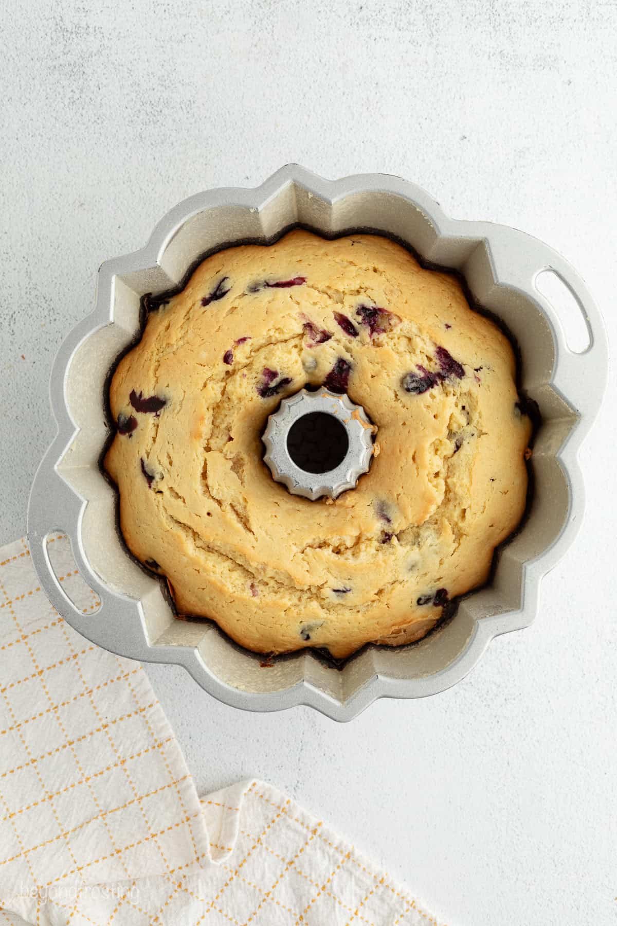 Baked lemon blueberry bundt cake in a pan.
