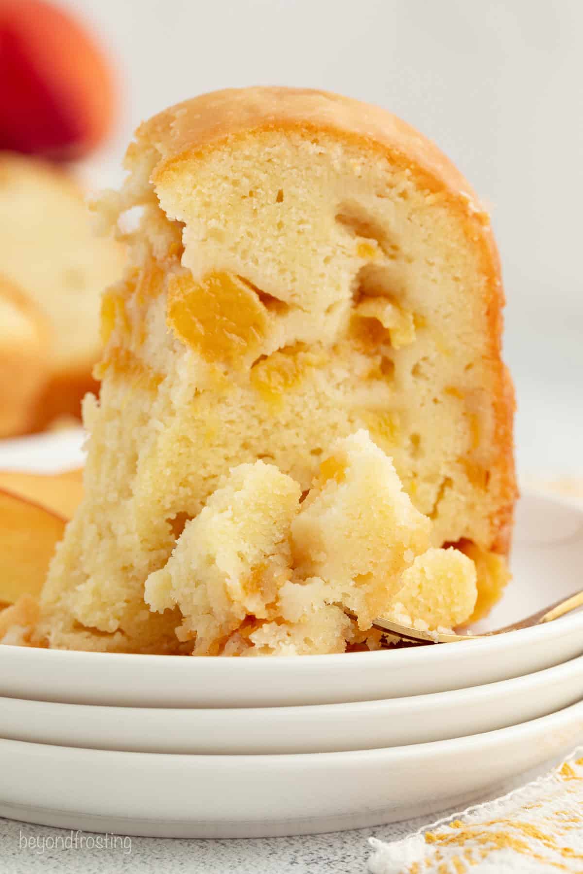 Close up of a slice of peach pound cake on a plate.