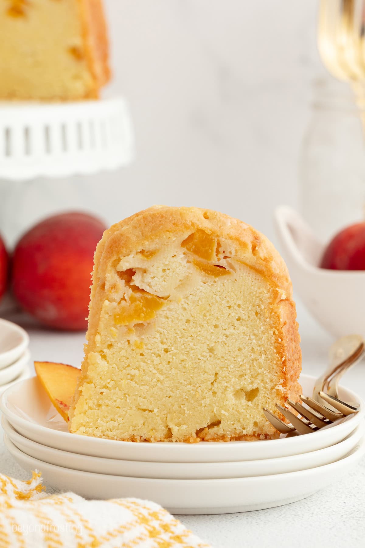 A slice of bourbon peach pound cake next to a fork on a plate.