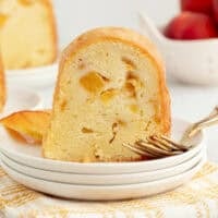A slice of bourbon peach pound cake next to a fork on a plate.