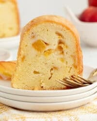 A slice of bourbon peach pound cake next to a fork on a plate.