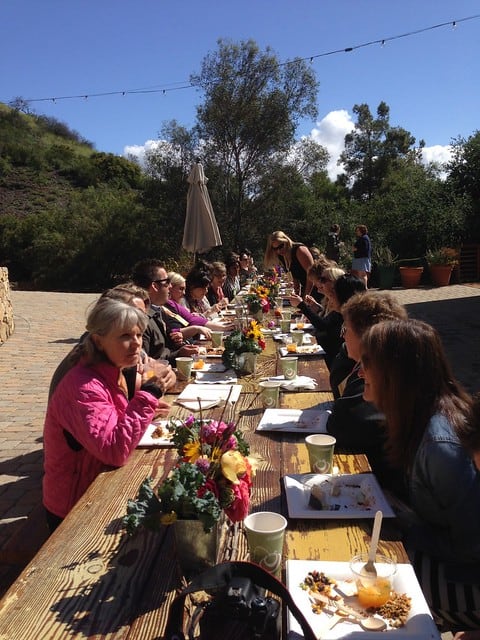 A long outdoor table of food bloggers at the Big Traveling Potluck conference