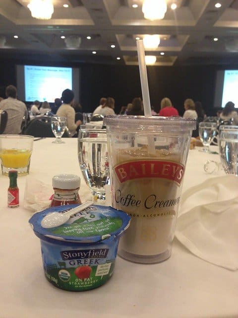 Stonyfield yogurt cup and Bailey's Coffee Creamer cup on a table at a conference