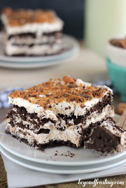 Side view of a serving of Butterfinger Icebox Cake on a plate with a bite on a fork