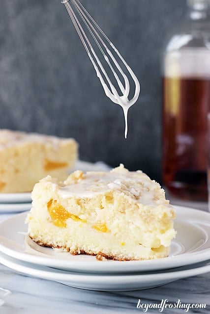 Icing being drizzled over a slice of Bourbon Peach Pound Cake on a plate