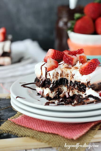 A serving of Brownie Brittle Strawberry Lasagna on a plate with a bite removed