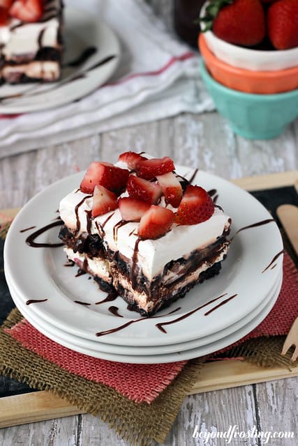 Overhead view of a serving of Brownie Brittle Strawberry Lasagna on a plate with chocolate drizzle
