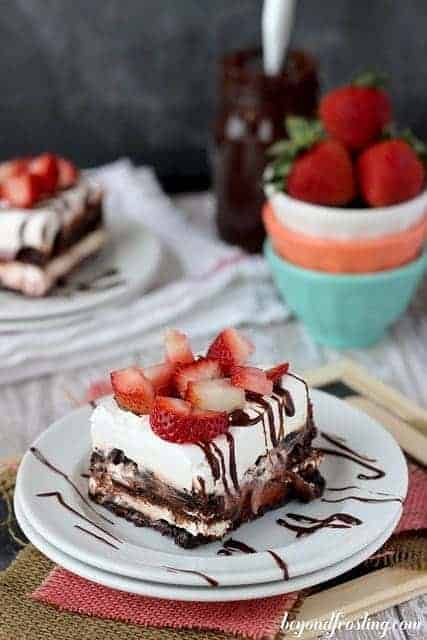 This strawberry lasagna is filled with cheesecake filling, dark chocolate pudding, brownie brittle, and is topped with fresh strawberries.