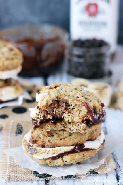 A stack of Bourbon Bacon Smores cookies on burlap with a bite out of one