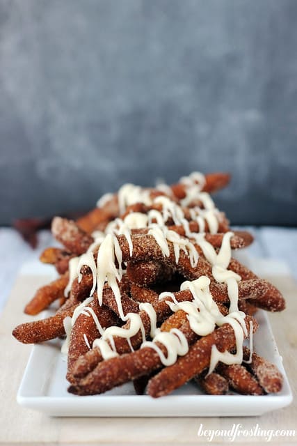Side view of Cinnamon Sugar Donut Fries with maple glaze on a plate