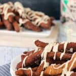 A tray of cinnamon sugar donut fries drenched in a maple glaze on a plate.