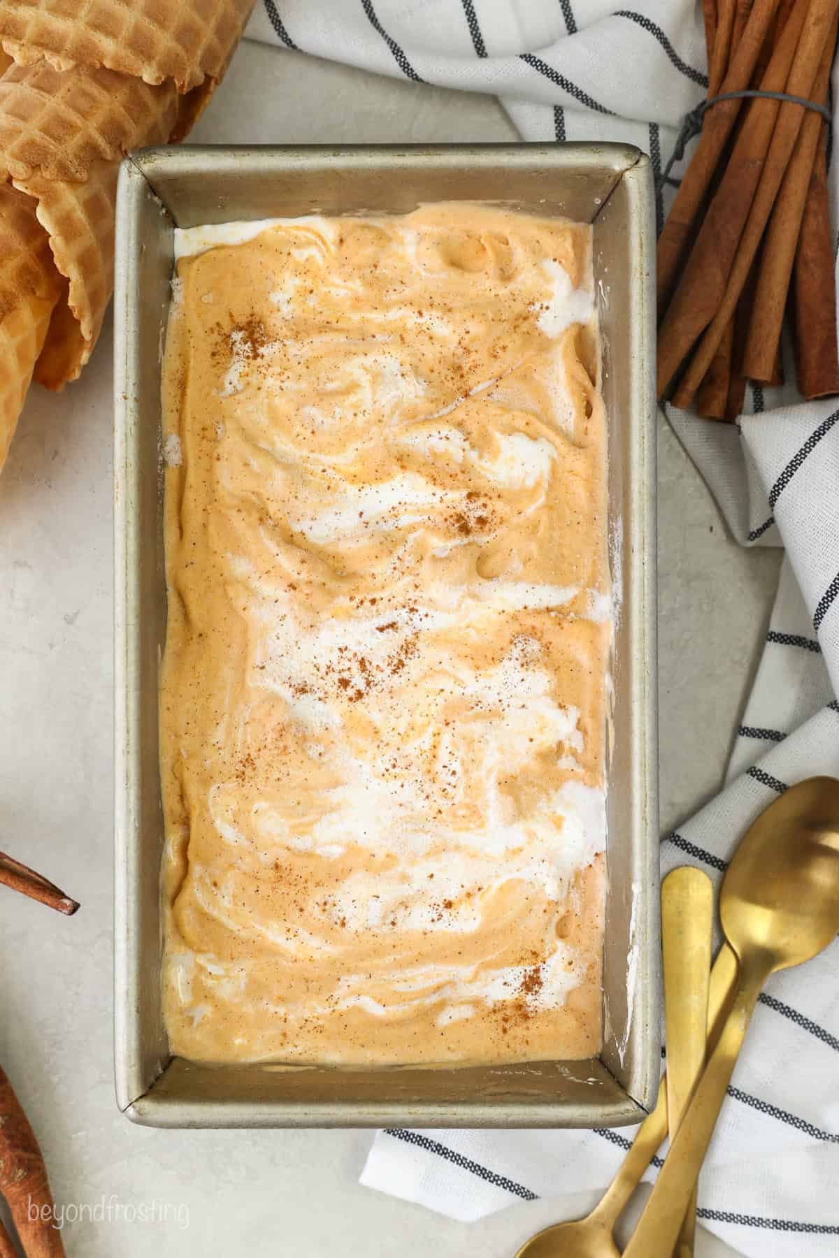 Overhead view of sweet potato ice cream swirled with marshmallow in a loaf pan.