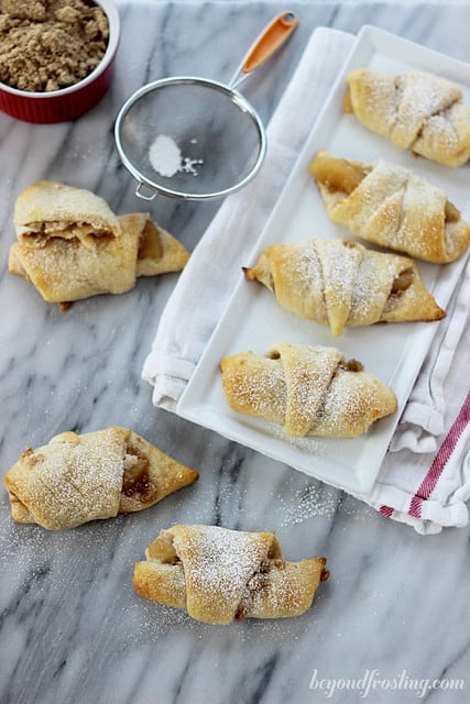 Overhead view of Apple Cheesecake Croissants on and around a white platter