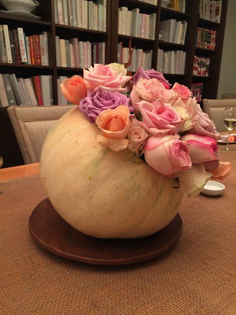 A flower arrangement in a gourd on a dining room table