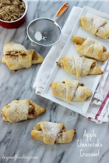 Overhead view of Apple Cheesecake Croissants on and around a platter 