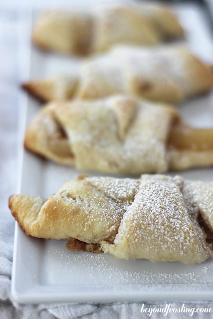 Close-up of four Apple Cheesecake Croissants on a white platter