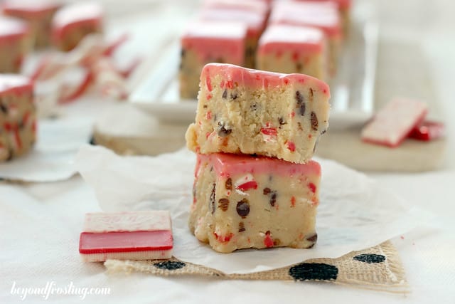 Two Andes Peppermint Crunch Cookie Dough Truffle Bars stacked on parchment paper with a bite out of the top one