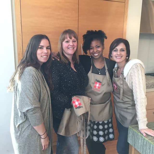 A group of four bloggers posing with aprons