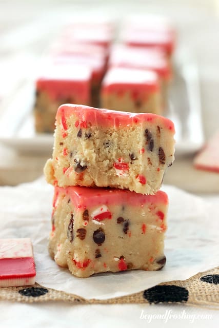 Two Andes Peppermint Crunch Cookie Dough Truffle Bars stacked on parchment paper with a bite out of the top one