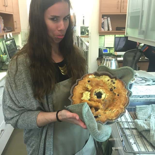 Author frowning and holding up a crumbling bundt cake in the pan