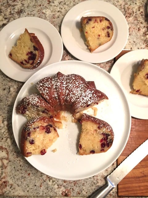 Overhead view of a cranberry bundt cake with a few slices on plates