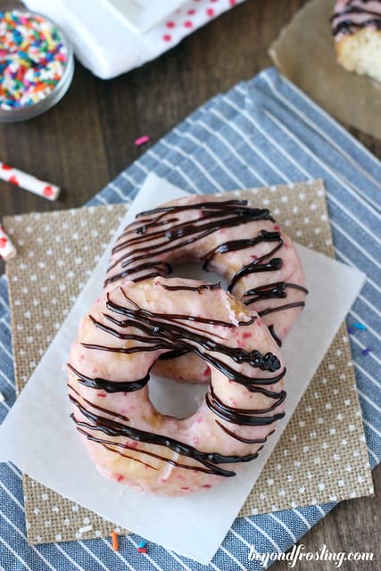 Overhead view of two Chocolate Covered Strawberry Donuts on a napkin