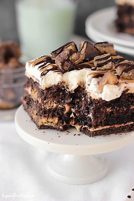 A square of Chocolate Peanut Butter Cup lasagna with a bite removed on a mini cake stand