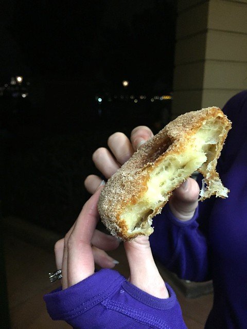Hands holding a half-eaten cronut